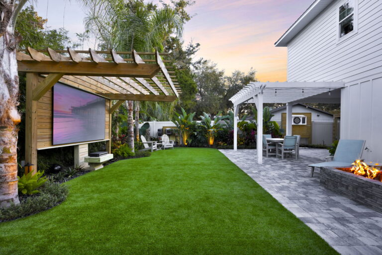 Lush green lawn with outdoor seating and fire pit at sunset.